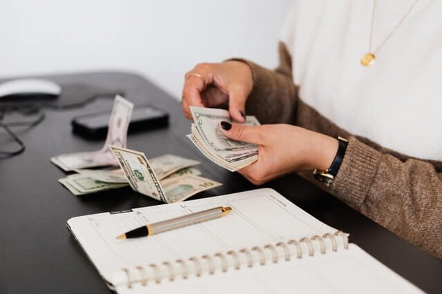 Crop Payroll Clerk Counting Money While Sitting At Table 1